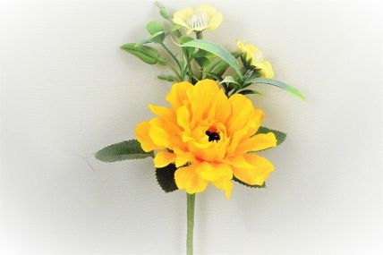 33009 - Bright Yellow floral arrangement accompanied with delicate Primrose flowers and leaves. Floral Pick. Height  17cms ,  Width  12cms   (approx)