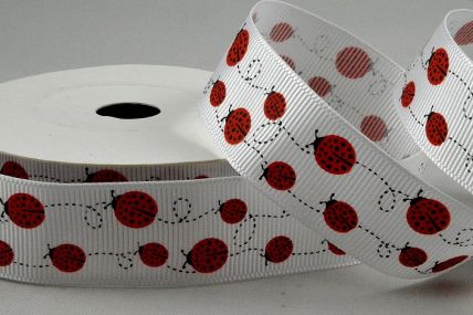 55136 - 22mm White grosgrain ribbon printed with a Swirling Lady Birds design x 10mts. 